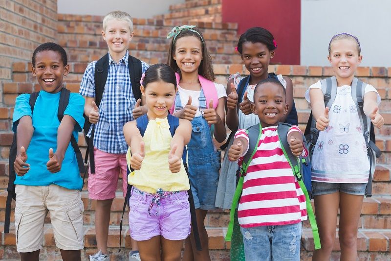 Group-of-kids-standing-on-staircase-showing-thumbs-up-comp