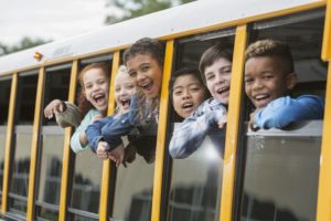 Elementary-school-children-looking-out-window-of-bus-cm
