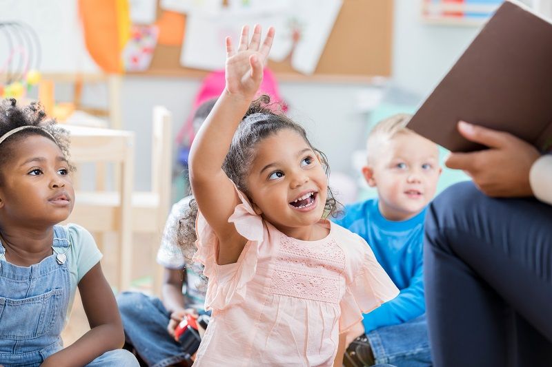 Little-girl-raises-her-hand-in-class-cm